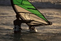 Surfer surfen mit Surfbrett und Kite am Strand — Stockfoto
