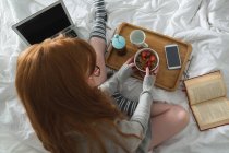 Donna che fa colazione in camera da letto a casa — Foto stock
