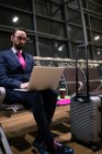 Empresário usando laptop na área de espera no aeroporto — Fotografia de Stock