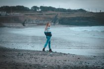 Mulher pensativa andando em uma praia — Fotografia de Stock