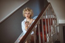 Giovane donna che utilizza il telefono cellulare a casa — Foto stock