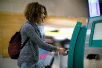 Frau benutzt Flugticket-Automaten am Flughafen — Stockfoto