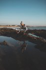 Frau spielt an einem sonnigen Tag mit Wasser am Strand — Stockfoto