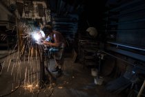 Herrero usando una linterna de soldadura en el taller - foto de stock
