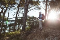 Seniorwanderer steht mit Rucksack im Wald auf dem Land — Stockfoto