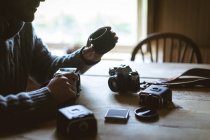 Seção média do homem reparando uma câmera em casa — Fotografia de Stock