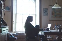 Молода жінка використовує ноутбук вдома — стокове фото