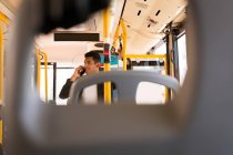 Young businessman talking on mobile phone while travelling in bus — Stock Photo