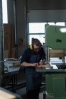 Menuisier masculin utilisant une machine de coupe verticale à l'atelier — Photo de stock