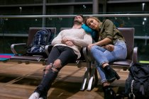 Пара спить в зоні очікування в аеропорту — стокове фото