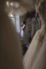 Біла наречена у весільній сукні, використовуючи мобільний телефон у бутіку — стокове фото
