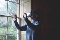 Femme utilisant casque de réalité virtuelle à la maison — Photo de stock