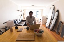 Homem caucasiano atento usando laptop em casa — Fotografia de Stock