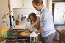 Батько і дочка готують піцу на кухні вдома — стокове фото