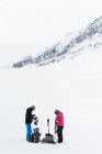 Couple wearing harness on a snow covered mountain during winter — Stock Photo