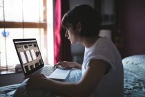Frau benutzt Laptop im Schlafzimmer zu Hause — Stockfoto