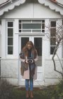 Femme prenant des photos avec un appareil photo vintage dans la cour de sa maison — Photo de stock