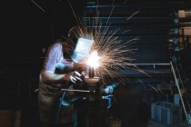 Blacksmith using a welding torch in workshop — Stock Photo