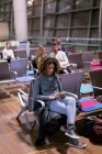 Жінка використовує мобільний телефон в зоні очікування в аеропорту — стокове фото