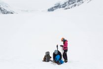 Пара носить ремни безопасности на заснеженной горе в течение зимы — стоковое фото