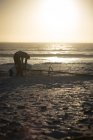 Мужчина-серфер готовит воздушного змея на пляже в сумерках — стоковое фото