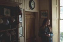 Mujer pensativa tomando café negro en casa - foto de stock