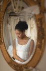 Riflessione della giovane sposa in abito da sposa a specchio — Foto stock