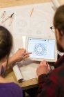 Carpinteros masculinos y femeninos mirando plan en tableta digital en taller - foto de stock
