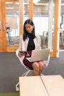 Ejecutivo femenino usando laptop y tableta digital en la oficina - foto de stock