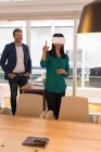 Executivo feminino usando fone de ouvido de realidade virtual no escritório — Fotografia de Stock