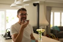 Man talking on mobile phone at home — Stock Photo