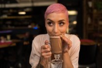 Stylish woman having chocolate milkshake at restaurant — Stock Photo
