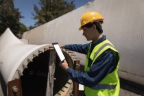 Работник-мужчина с помощью цифрового планшета при исследовании бетонного тоннеля на солнечной станции — стоковое фото