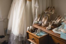 Various wedding dresses and footwear in boutique — Stock Photo