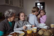 Família de várias gerações tomando café da manhã na cozinha em casa — Fotografia de Stock
