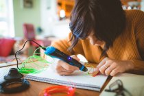 Frau zeichnet Skizze in Buch zu Hause — Stockfoto