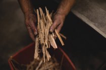 Schmied hält Holzstäbe in Werkstatt — Stockfoto