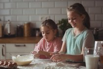 Siblings preparing cupcake in kitchen at home — Stock Photo
