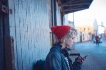 Молода жінка використовує мобільний телефон біля міської вулиці — стокове фото