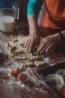 Section du milieu de la femme âgée préparant des biscuits dans la cuisine à la maison — Photo de stock