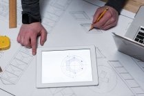 Carpinteiro masculino desenhando um gráfico em papel de carta na oficina — Fotografia de Stock