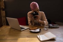 Mulher elegante clicando foto do café da manhã com câmera no restaurante — Fotografia de Stock