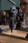 Carpinteiro feminino usando máquina de broca vertical na oficina — Fotografia de Stock