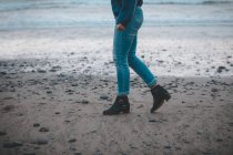 Sezione bassa di donna che cammina su una spiaggia — Foto stock
