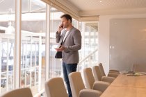 Uomo d'affari che parla al cellulare in sala conferenze in ufficio — Foto stock