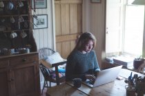Mujer joven usando el ordenador portátil en casa - foto de stock
