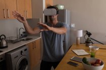 Hombre usando auriculares de realidad virtual en casa - foto de stock