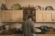 Вид сзади на человека, работающего на кухне дома — стоковое фото