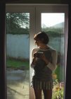 Mulher atenciosa tomando café perto da janela em casa — Fotografia de Stock