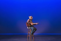 Uomo che suona la chitarra sul palco a teatro — Foto stock